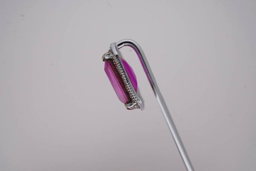 A North American? 10k white metal and single stone emerald cut synthetic ruby set stick pin, 55mm, gross weight 1.1 grams. Condition - fair to good